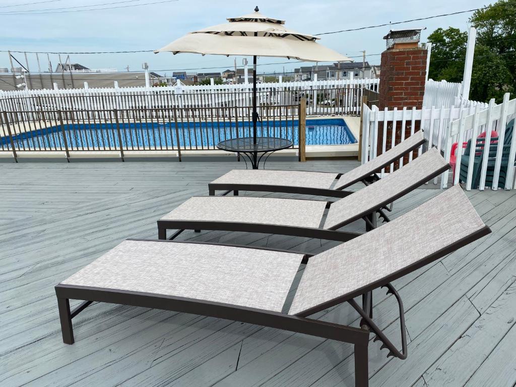 two benches sitting on a deck with an umbrella at Ways Motel in Hampton