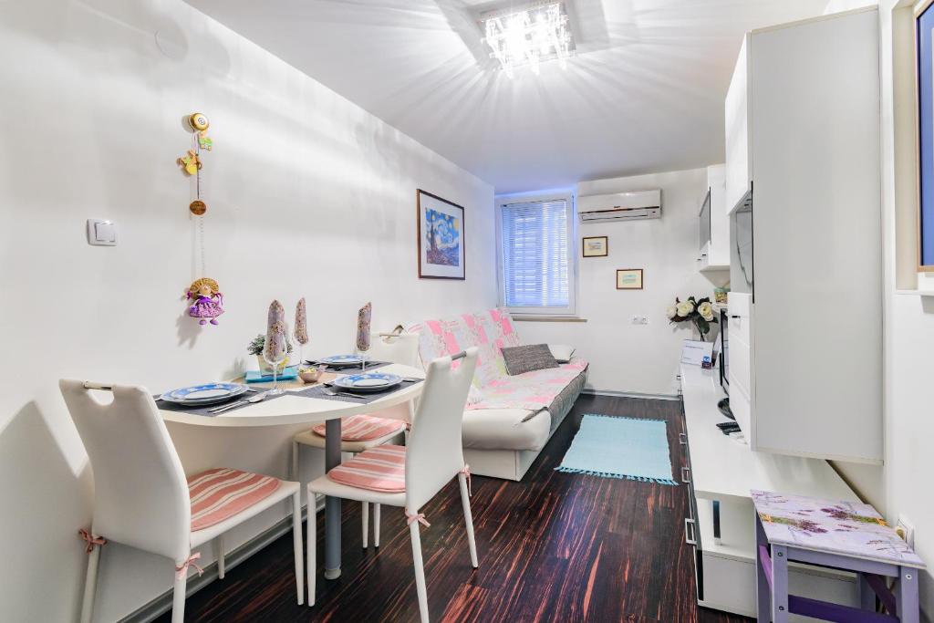 - un salon blanc avec une table et des chaises dans l'établissement MaJo Apartma Punta, à Piran