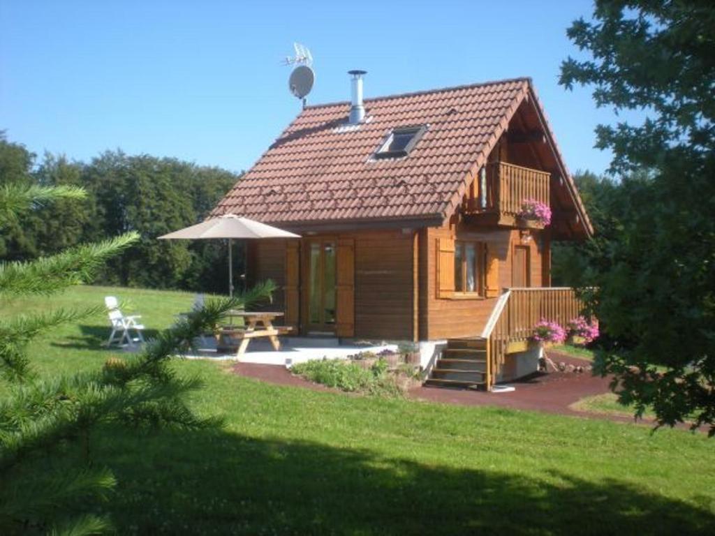 a small wooden cabin with a table and an umbrella at Gîte Le Val-d'Ajol, 2 pièces, 2 personnes - FR-1-589-230 in Le Val-dʼAjol