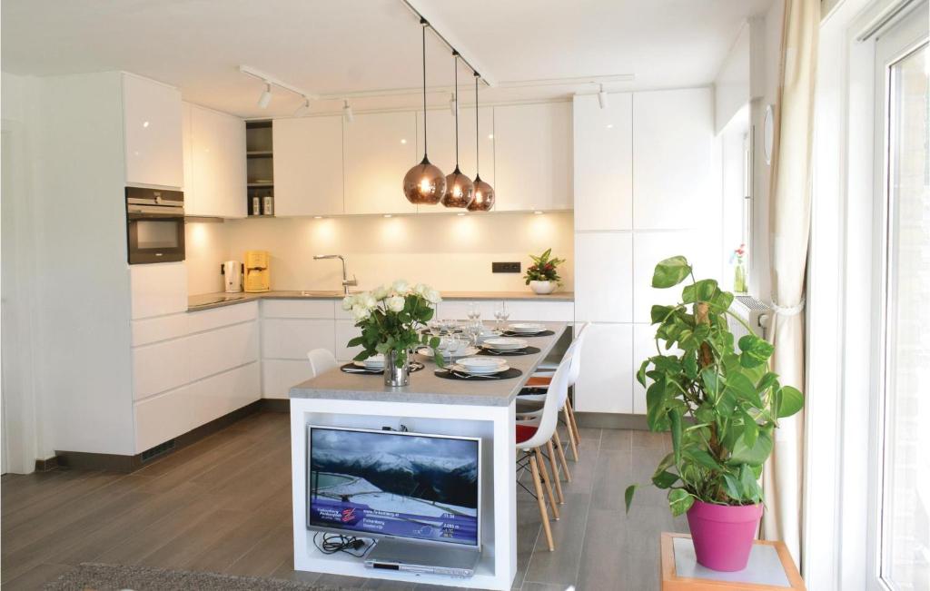 una cocina con TV en una isla con mesa en Goudstrand en Oostduinkerke