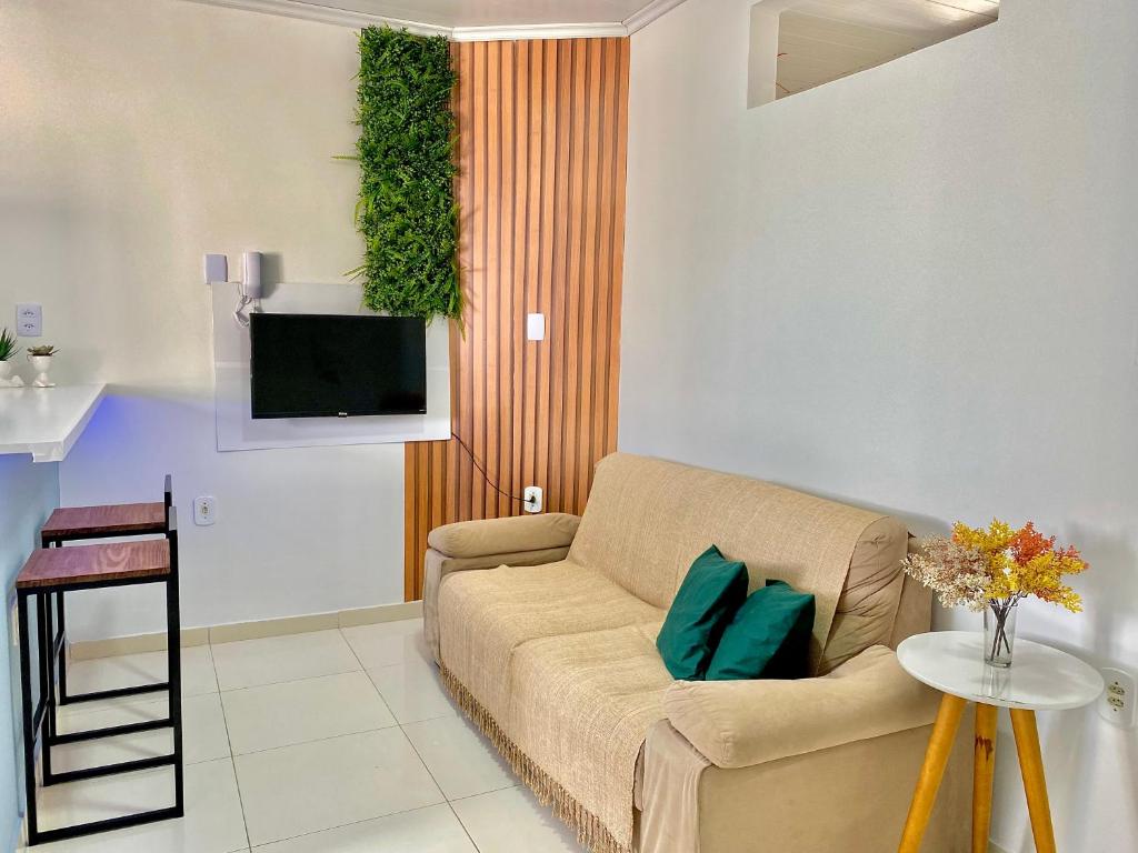 a living room with a couch and a tv at Village Caranguejo - Flat com 02 Quartos in Aracaju