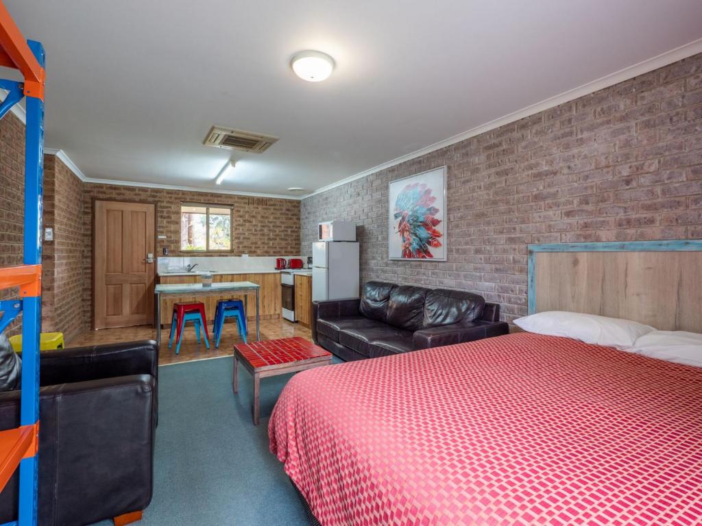 a bedroom with a bed and a brick wall at Eildon Parkview Motor Inn Room 10 in Eildon