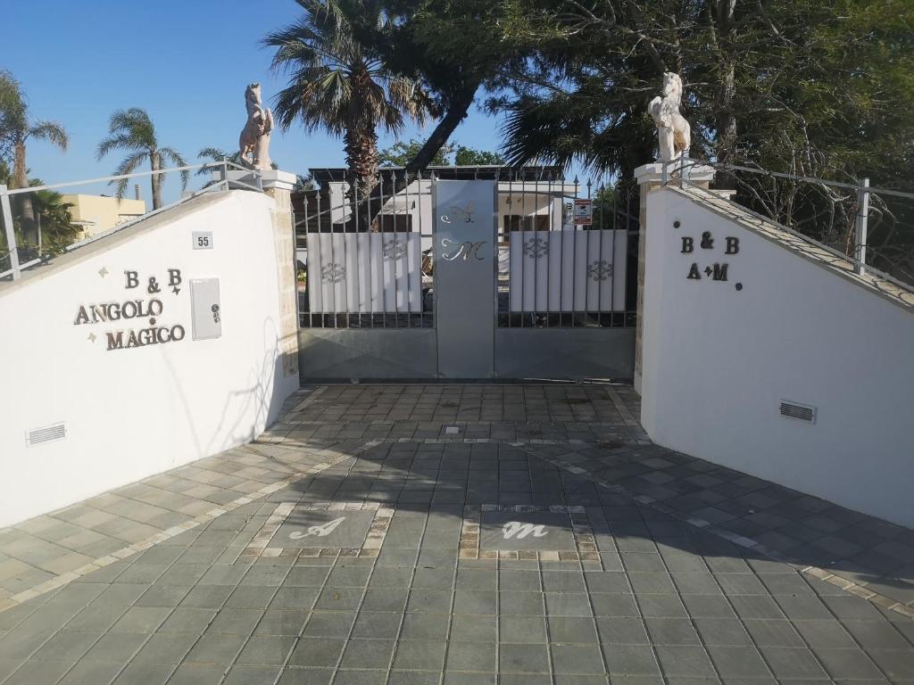 um portão para um complexo com uma cerca branca em B&B Angolo Magico em Baia Di Gallipoli