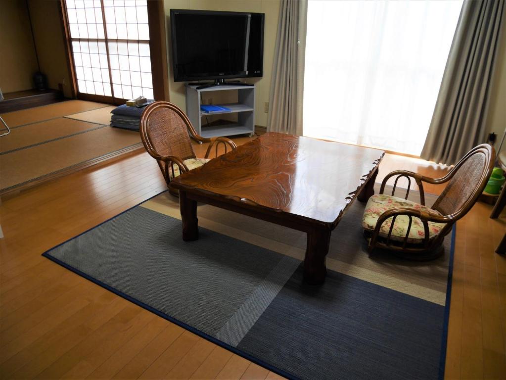 - un salon avec une table et des chaises en bois dans l'établissement Guest House Inujima / Vacation STAY 3516, à Toyama