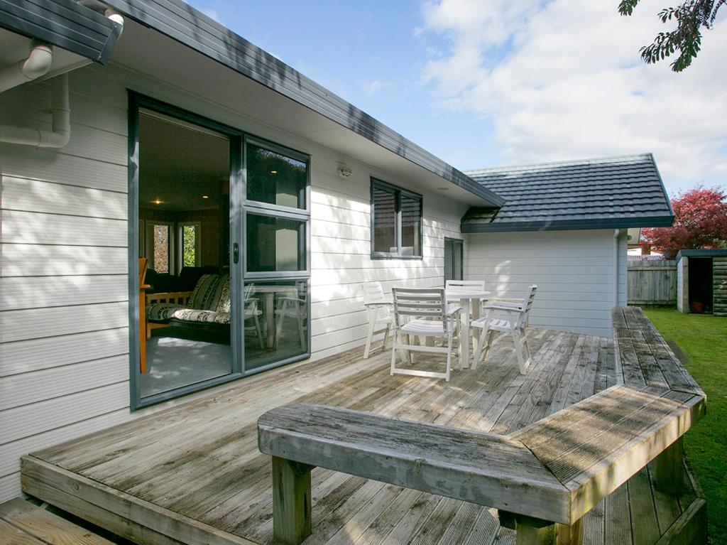 a deck with a table and chairs on a house at Laid Back on Lakewood - Taupo Holiday Home in Taupo