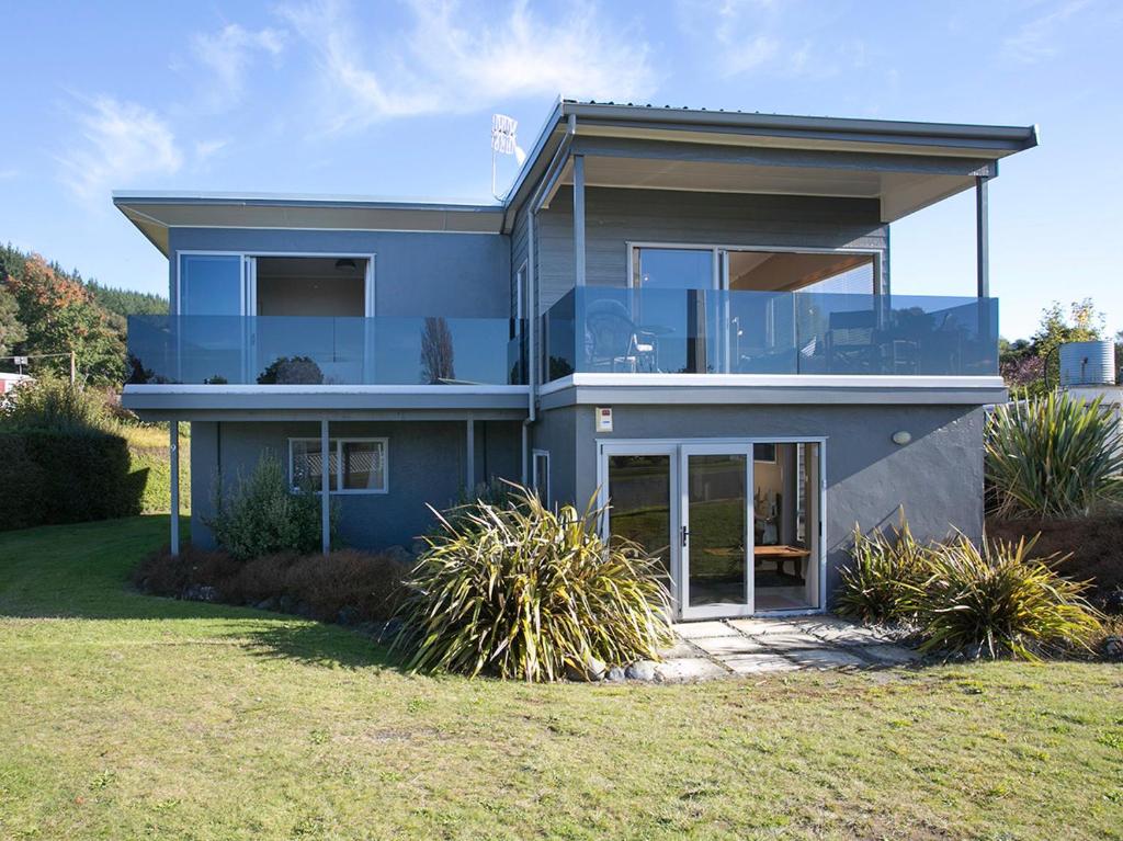 uma grande casa azul com um relvado em frente em Perfect Position - Motuoapa Holiday Home em Turangi