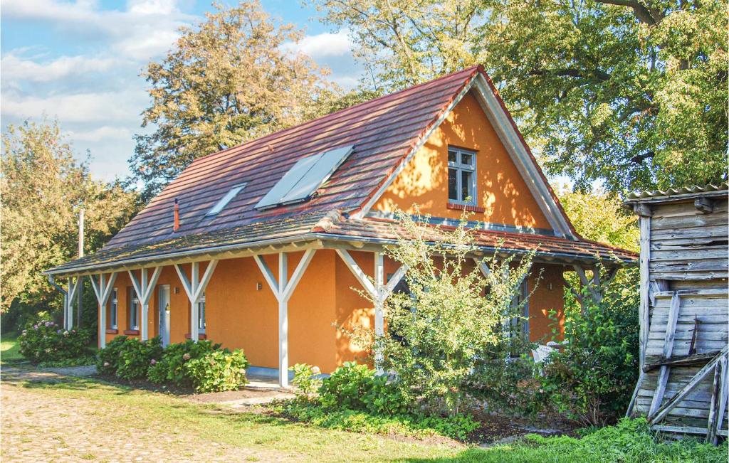 ein kleines orangefarbenes Haus mit einem Gamer-Dach in der Unterkunft Ferienhaus Hauptstr. R in Karwesee