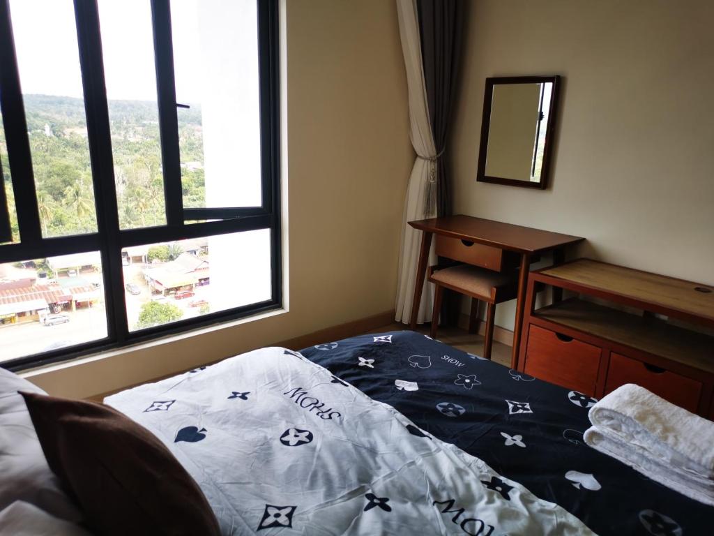 um quarto com uma cama, uma secretária e uma janela em Kiki Homestay @ Timurbay, Kuantan em Kampung Sungai Karang