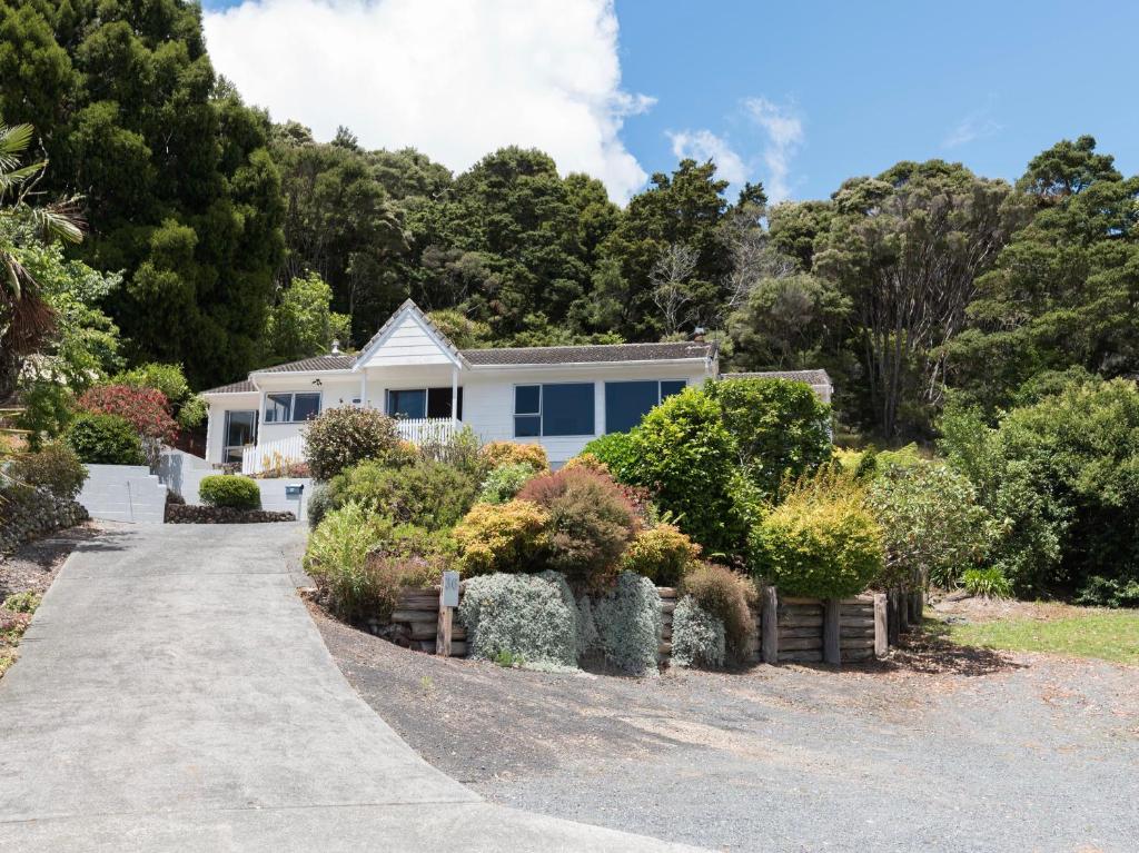 ein weißes Haus mit Büschen und Bäumen in der Unterkunft Central Spacious Family House - Paihia House in Paihia