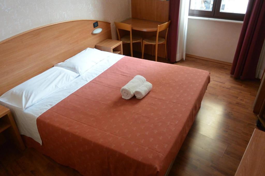una camera d'albergo con un letto e due asciugamani di Hotel Nuovo a Milano