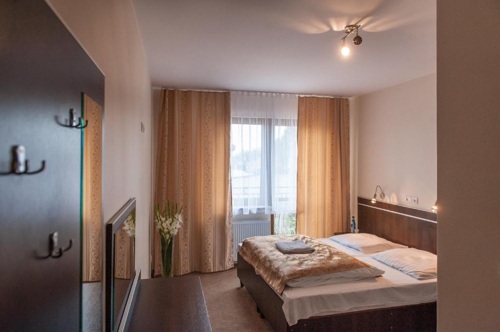 a hotel room with a bed and a window at Hotel E7 in Radom