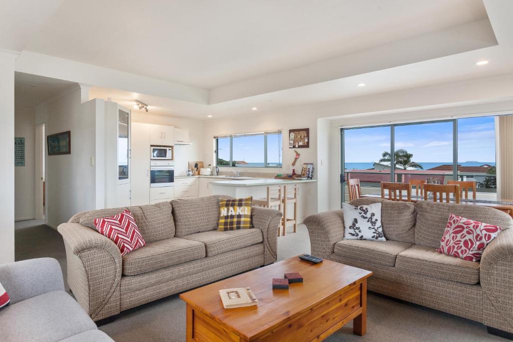 a living room with two couches and a table at White Island Views - Ohope Holiday Home in Ohope Beach