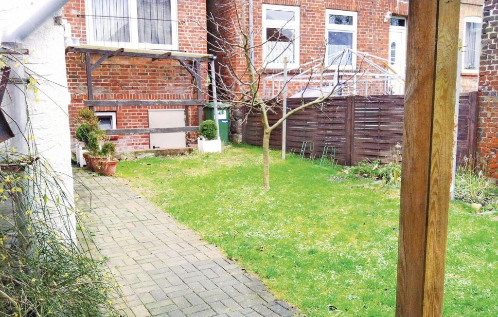 a small tree in a yard next to a brick building at Stunning Apartment In Schnberg With 1 Bedrooms in Schönberg