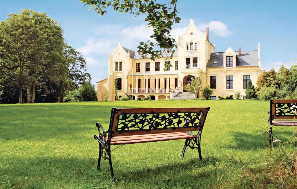 a park bench in front of a large house at Schloss Poggelow in Schwasdorf