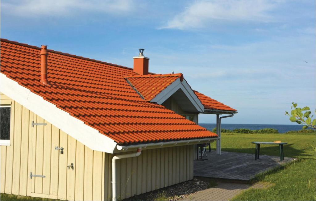 シェーンハーゲンにあるStrandblick 33のオレンジの屋根とピクニックテーブルのある建物