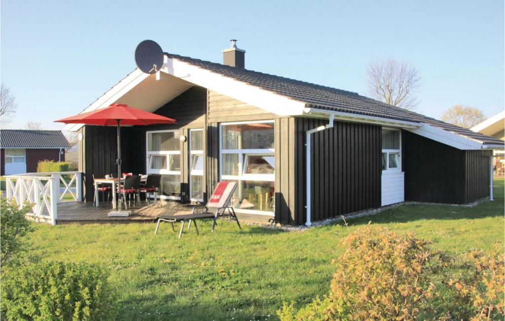 una casa con terrazza e ombrellone rosso di Strandpark 21 a Schönhagen
