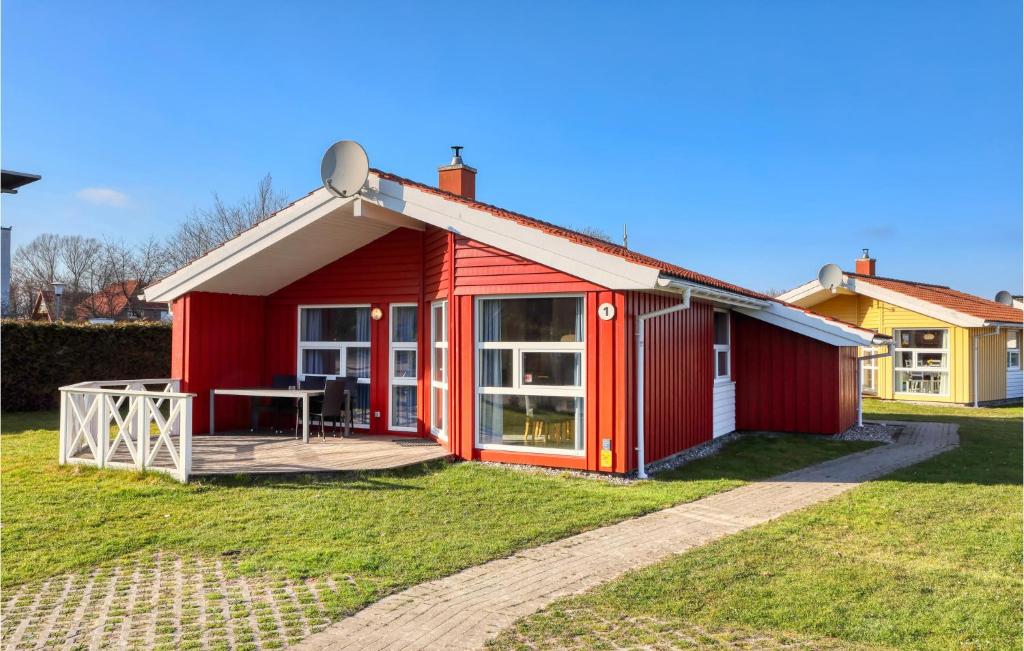 ein rotes Haus mit einer Grasterrasse in der Unterkunft Strandpark 1 in Schönhagen
