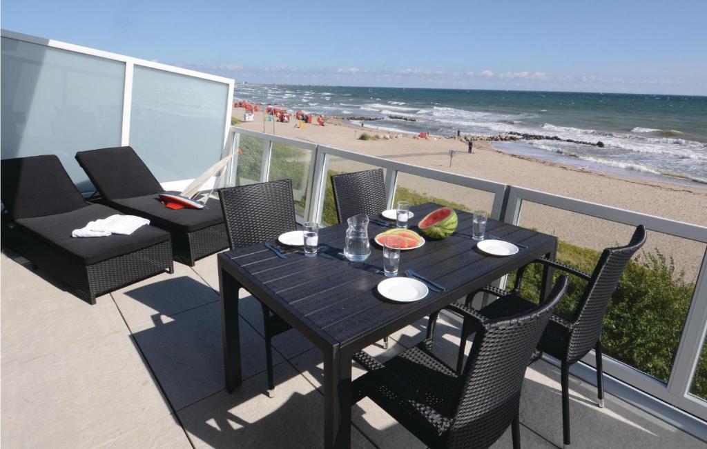 a table on a balcony with a view of the beach at Appartement Seestern F in Schönhagen