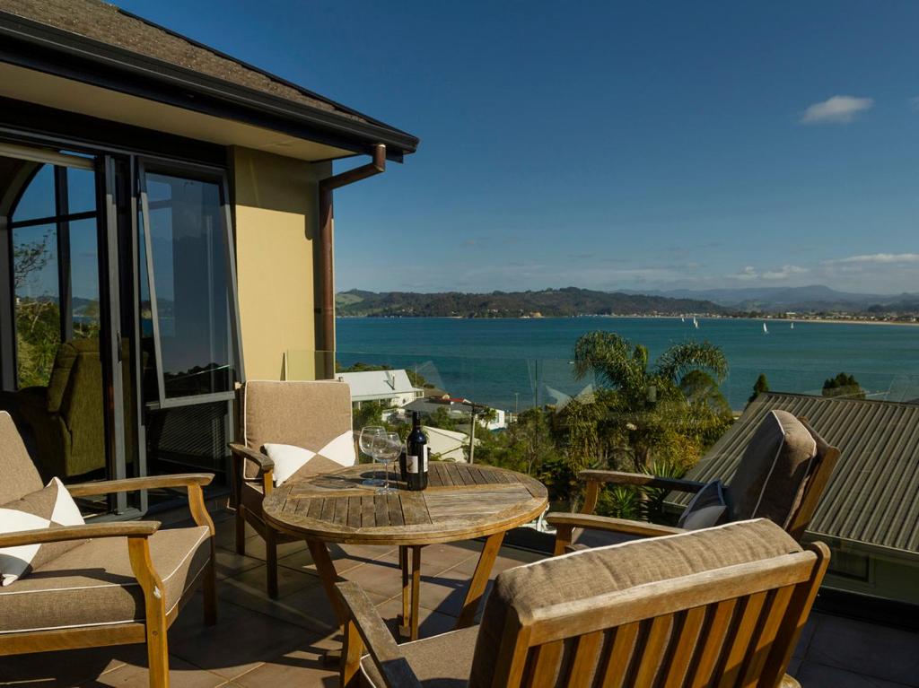 d'une terrasse avec une table et des chaises et une vue sur l'eau. dans l'établissement View from the Top - Whitianga Holiday Home, à Whitianga