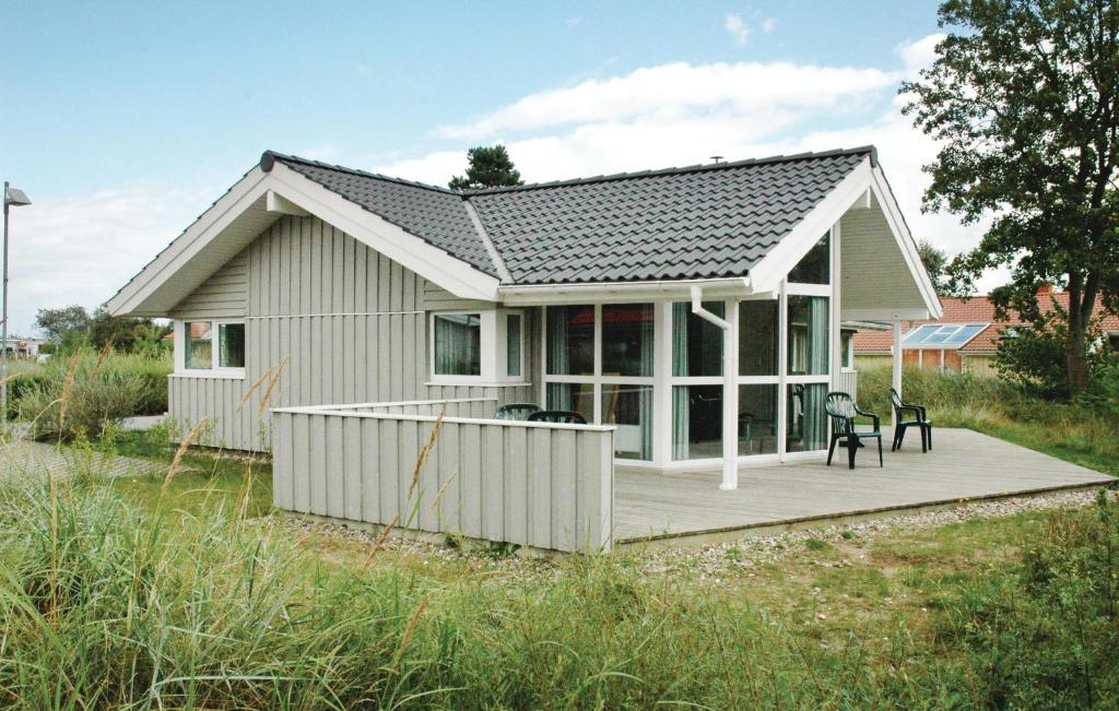 ein kleines Haus mit einer Terrasse auf einem Feld in der Unterkunft Strandblick 10 - Dorf 1 in Travemünde
