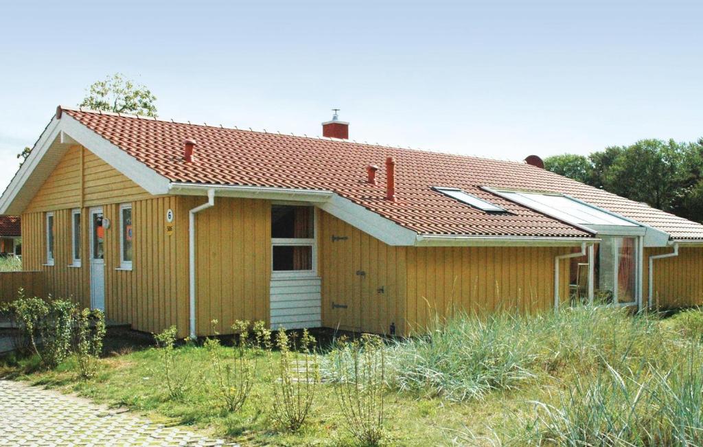 una pequeña casa amarilla con techo rojo en Strandblick 6 - Dorf 1, en Travemünde