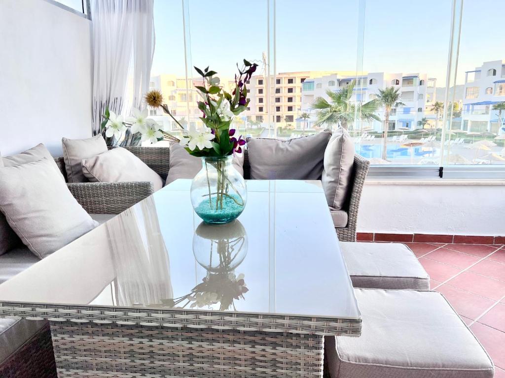 - un vase en verre avec des fleurs sur une table dans le salon dans l'établissement Sophia's home, à Cabo Negro