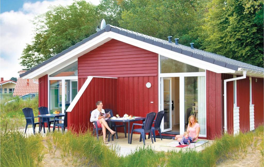 a man and woman sitting at a table in a red shed at Schmugglerstieg 9a - Dorf 5 in Travemünde