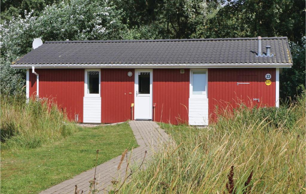a red building with white doors and a path at Freibeuterweg 22 - Dorf 5 in Travemünde