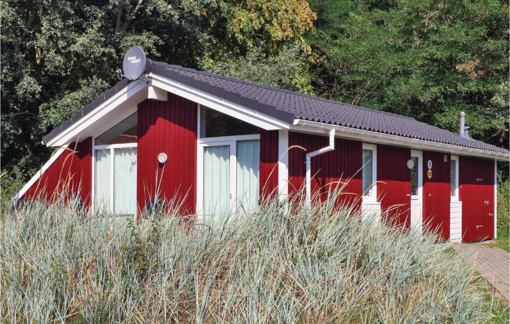 un hangar rouge et blanc avec un toit noir dans l'établissement Pulverhorn 5 - Dorf 4, à Travemünde