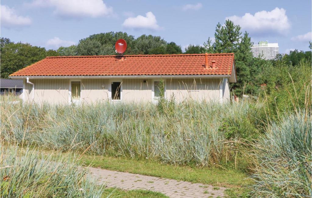a house with a red roof in a field at Schatzkiste 11 - Dorf 4 in Travemünde