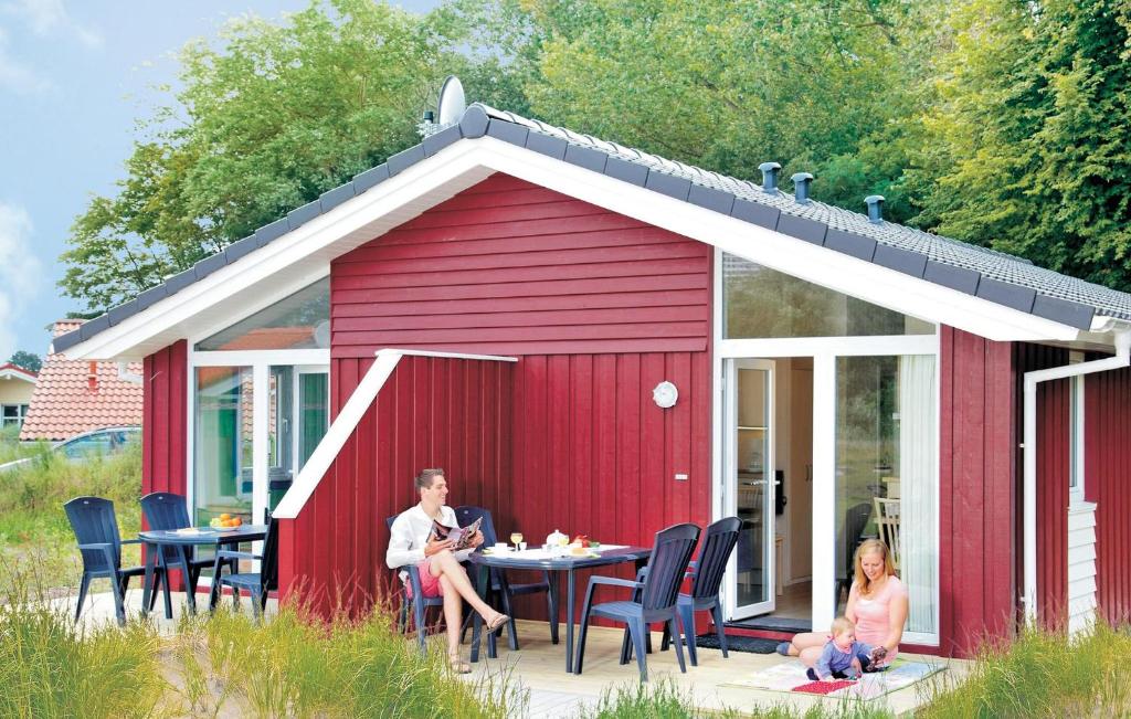 a man and woman sitting at a table in a red shed at Schmugglerstieg 9b - Dorf 5 in Travemünde