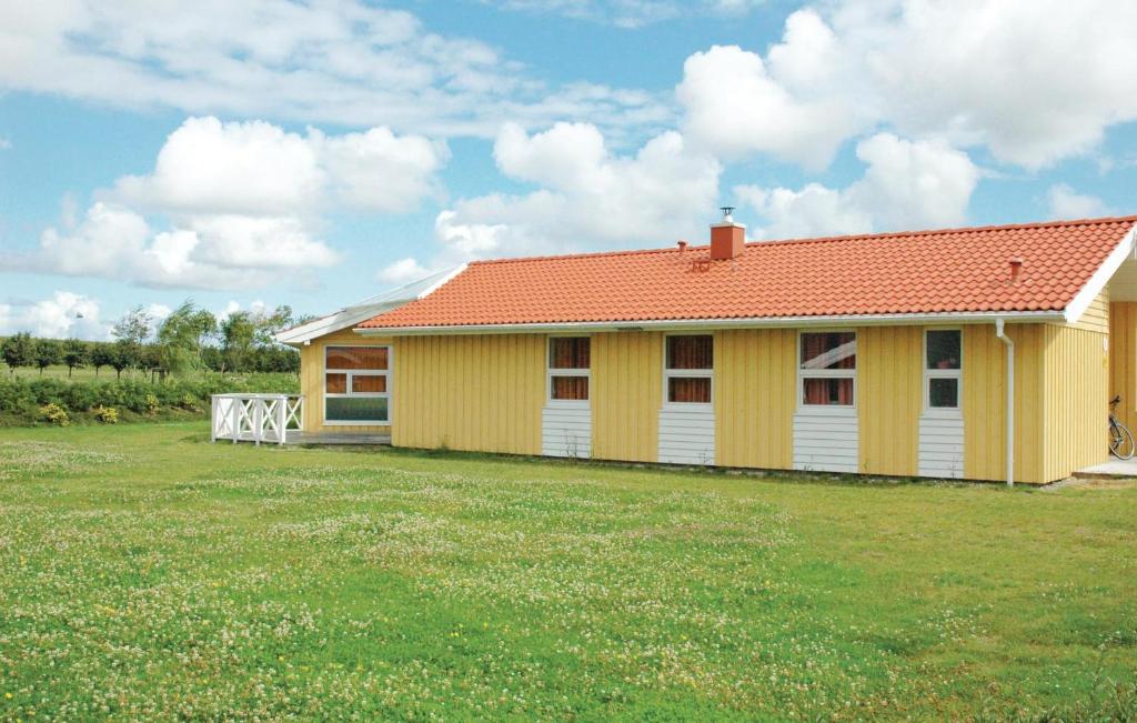 ein gelbes Haus mit orangefarbenem Dach auf einem Hof in der Unterkunft Friedrichskoog-strandpark 3 in Friedrichskoog