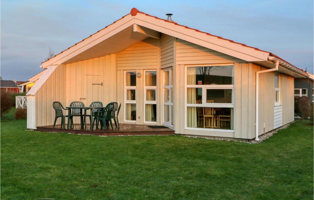 a house with a table and chairs in a yard at Friedrichskoog-Strandpark 18 in Friedrichskoog