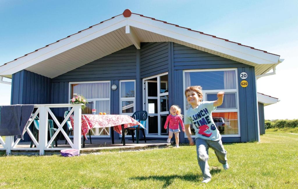 Ein kleiner Junge, der vor einem blauen Haus rennt. in der Unterkunft Friedrichskoog-strandpark 20 in Friedrichskoog