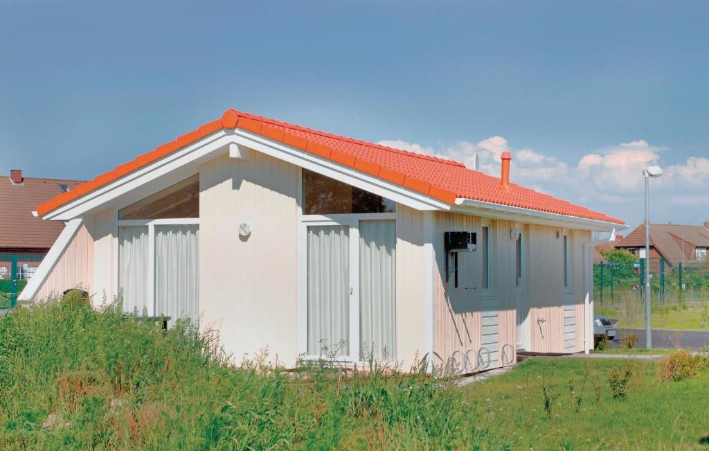 ein kleines weißes Gebäude mit orangefarbenem Dach in der Unterkunft Friedrichskoog-deichblick 2 in Friedrichskoog