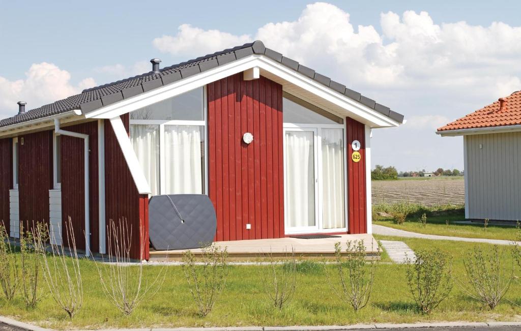 ein kleines rotes Haus mit einem großen Fenster in der Unterkunft Friedrichskoog-deichblick 1 in Friedrichskoog