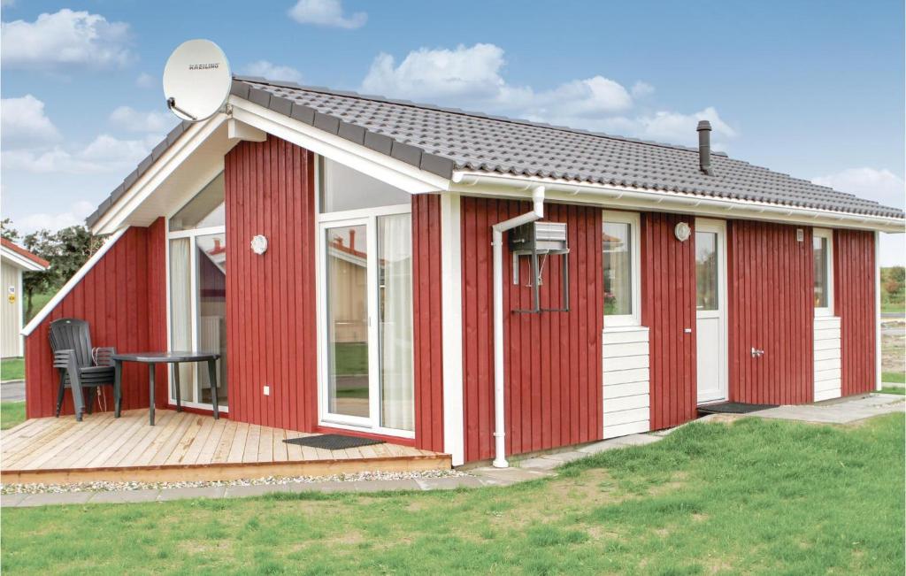 a red and white house with a deck at Friedrichskoog-Deichblick 9 in Friedrichskoog