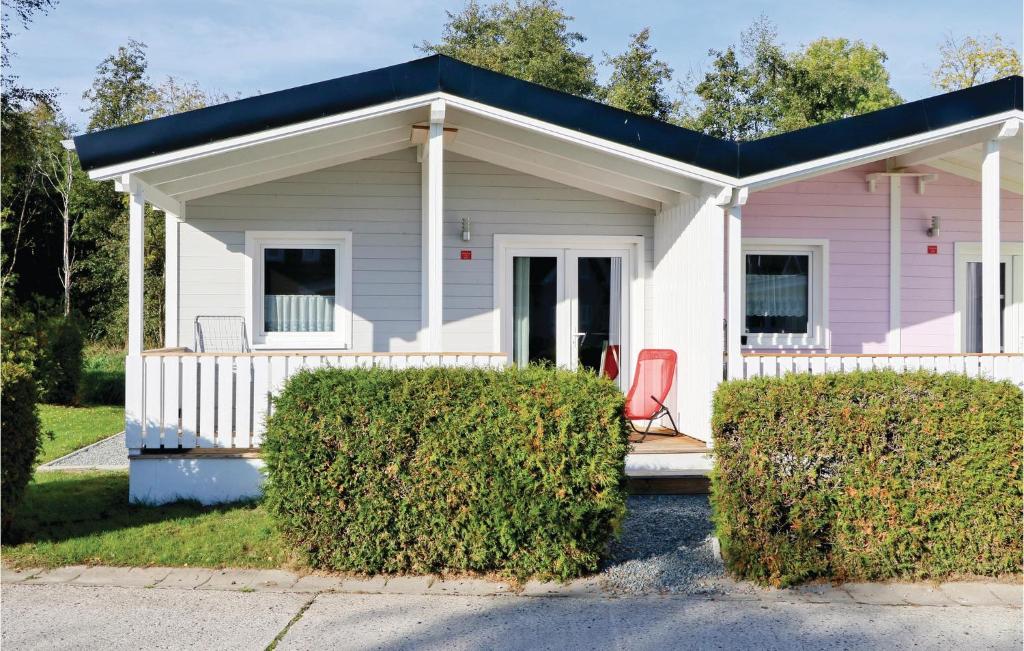 ein rosa Haus mit einem roten Stuhl davor in der Unterkunft Ferienhaus Haustyp R in Süssau