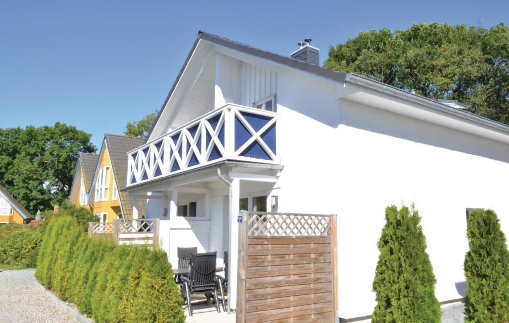 ein weißes Haus mit einem Zaun und Bäumen in der Unterkunft Haus Seeadler 2 in Süssau