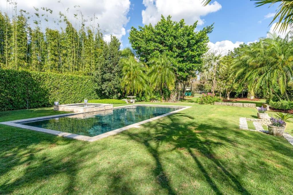 una piscina en un patio con césped y árboles en The Garden House Hot Tub Pool and Lush Garden Oasis, en Homestead