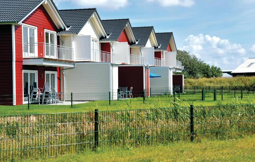 eine Reihe von Häusern auf einem Feld mit einem Zaun in der Unterkunft Ferienhaus K�stenweg I in Dagebüll