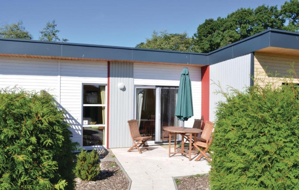 eine Terrasse mit einem Tisch, Stühlen und einem Sonnenschirm in der Unterkunft Ferienhaus Seeigel N in Süssau