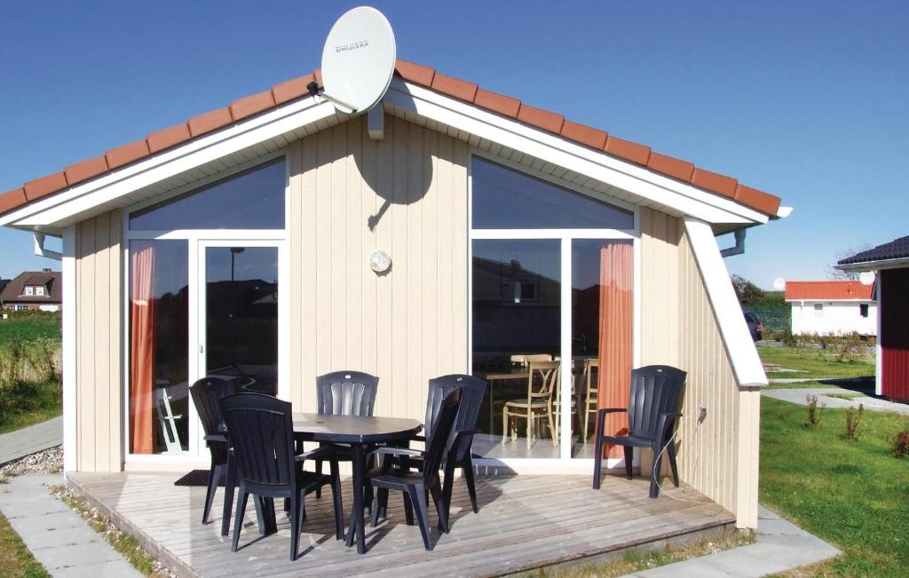 einen Pavillon mit einem Tisch und Stühlen auf einer Terrasse in der Unterkunft Friedrichskoog-deichblick 5 in Friedrichskoog