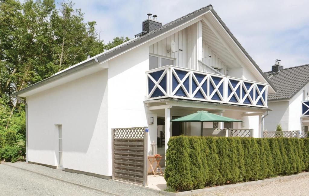 a white house with a blue and white balcony at Haus Seeadler 1 in Süssau