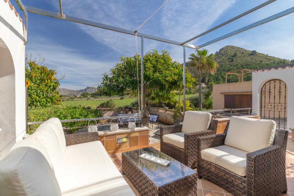a patio with chairs and a table and a view of mountains at Mallorca Holiday House for Rent Del mar 37 in Colonia de Sant Pere