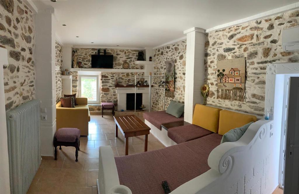 a living room with a stone wall at Sea&Stone Apartment in Skala Sotiros