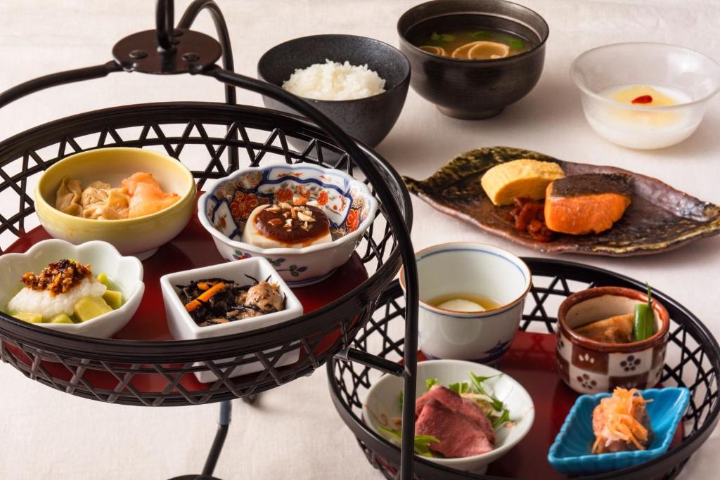 a table topped with bowls of food on a table at Rihga Royal Hotel Hiroshima in Hiroshima