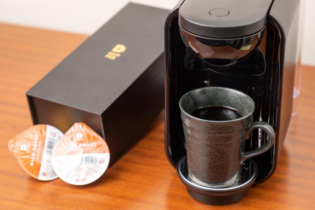 a coffee maker sitting on a table next to a box at Rihga Royal Hotel Hiroshima in Hiroshima