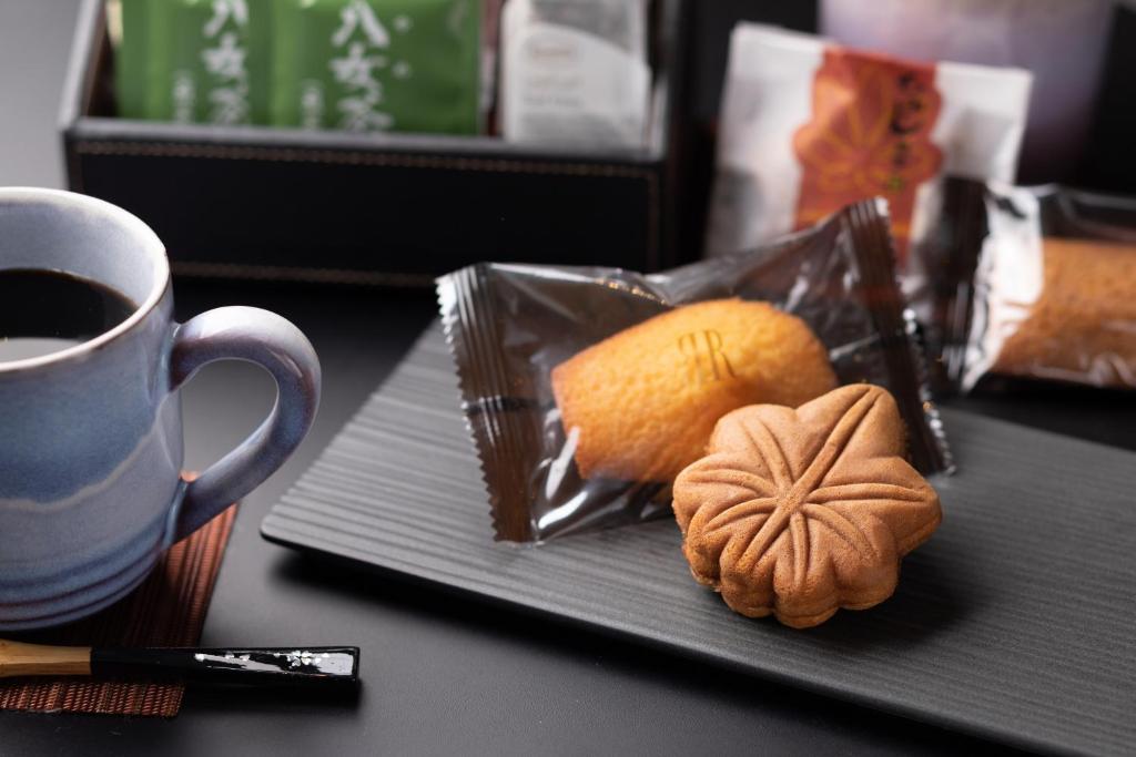 a table with a cup of coffee and a plate of food at Rihga Royal Hotel Hiroshima in Hiroshima