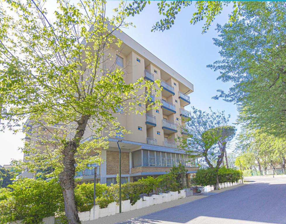 Un edificio alto con un albero davanti di Hotel Ben Hur a Cesenatico